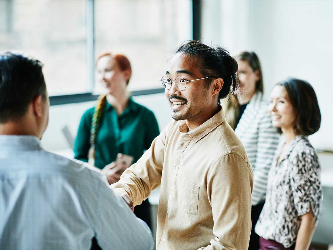 Businessman shaking hands with colleague after meeting in office