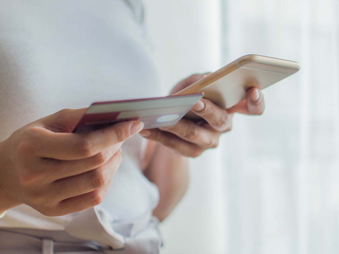 Woman using mobile device and credit card